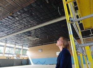 Ein zuversichtlicher Blick nach oben: Gebäudemanagerin Claudia Middelhoff hofft, dass die Arbeiten in der Emssporthalle bis Ferienende abgeschlossen sind. Foto: tst